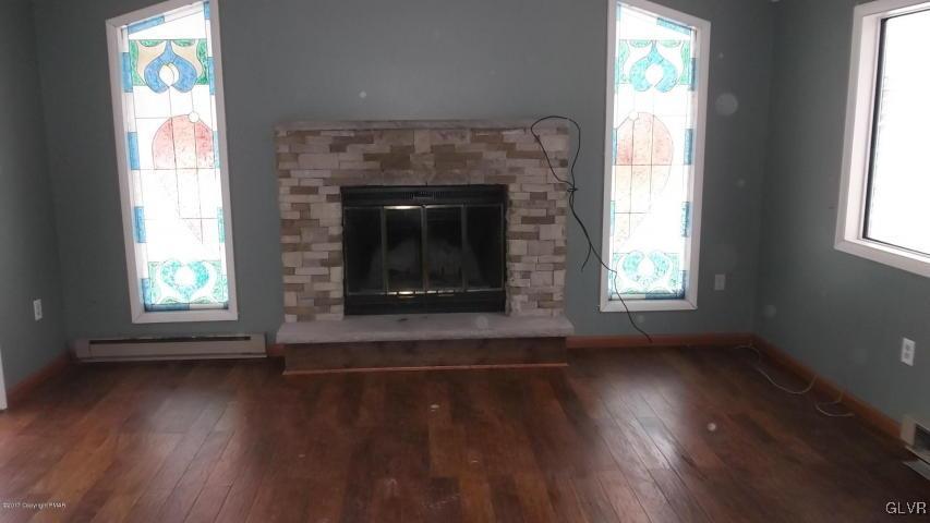 1623 Cotswald Road Tobyhanna, PA 18466 - Photo 3 of 14 an empty room with wooden floor windows and a fireplace