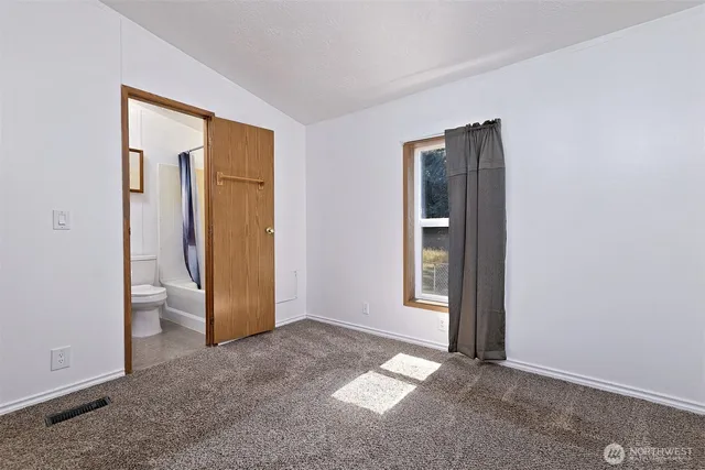 an empty room with closet and windows