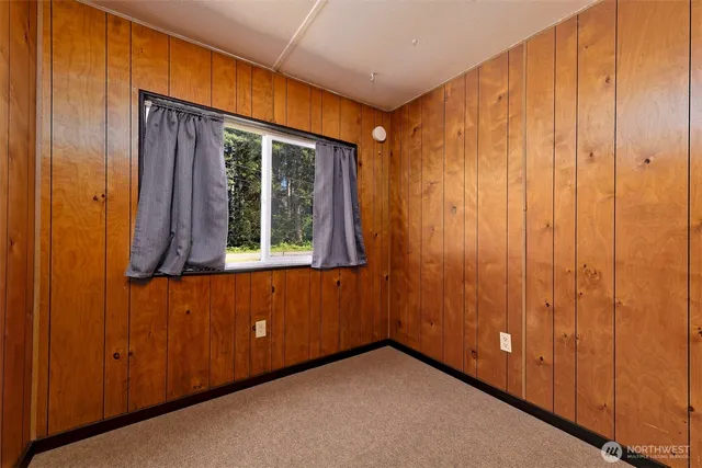 a backyard of a house with wooden fence and large trees