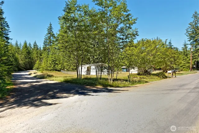 a view of a house with a big yard and large trees