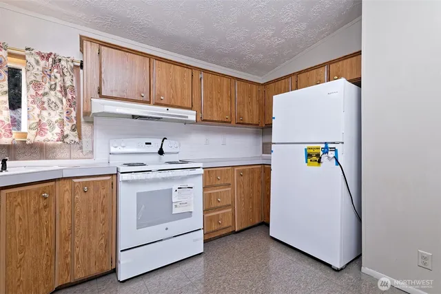 a kitchen with sink cabinets and white appliances