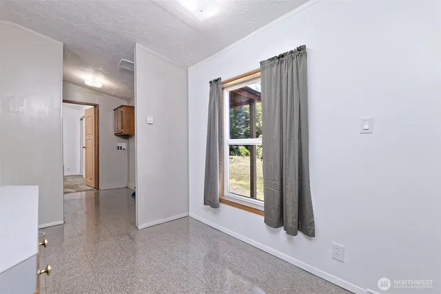 a view of an empty room with a fireplace and a window