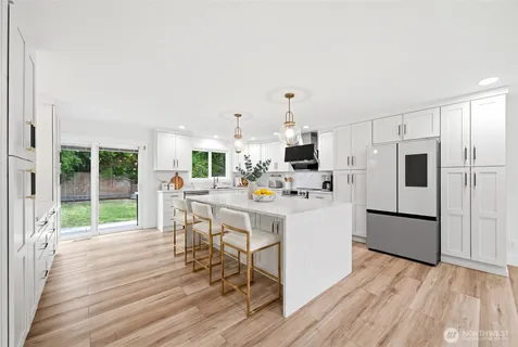 a kitchen view with white cabinets and stainless steel appliances