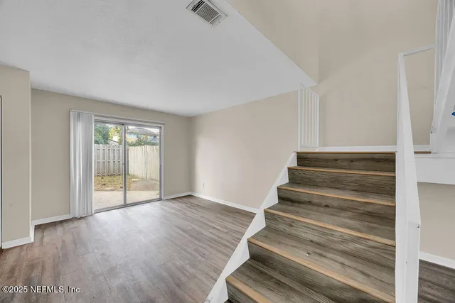 a view of an entryway with wooden floor and door
