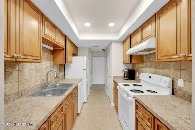 a kitchen that has a sink a stove and a oven