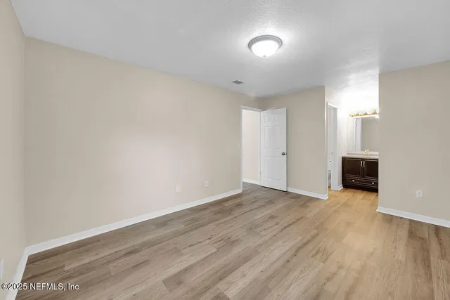 a view of an empty room with wooden floor