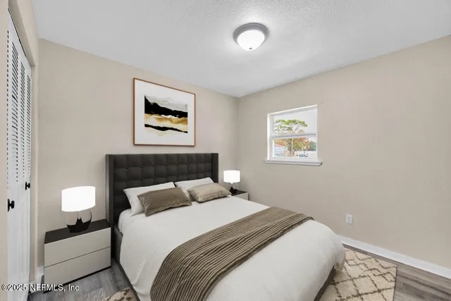 a bedroom with a bed and a painting on the wall