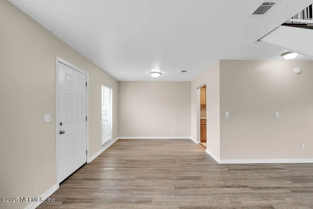 a view of an empty room with wooden floor