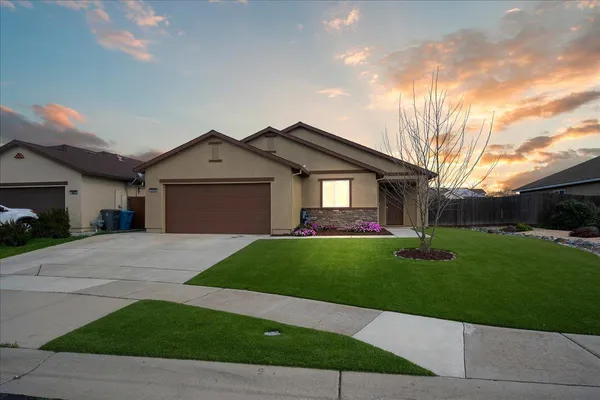 a front view of a house with a yard and garage