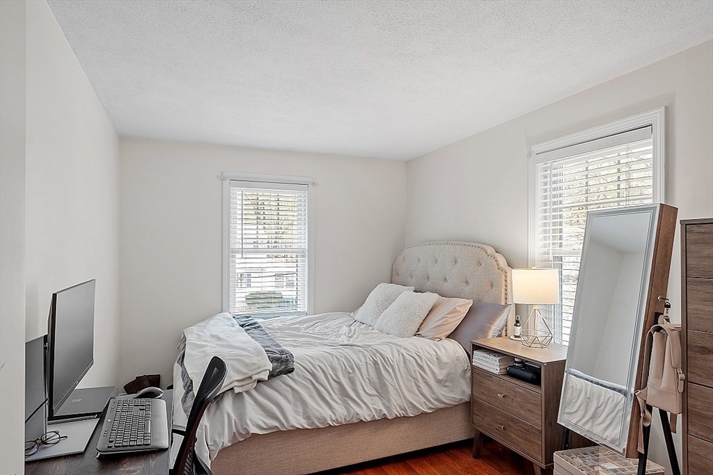 26 Pondover Road, Unit 26 Billerica, MA 01821 - Photo 11 of 23 a bedroom with a bed wooden floor and a flat tv screen on a dresser