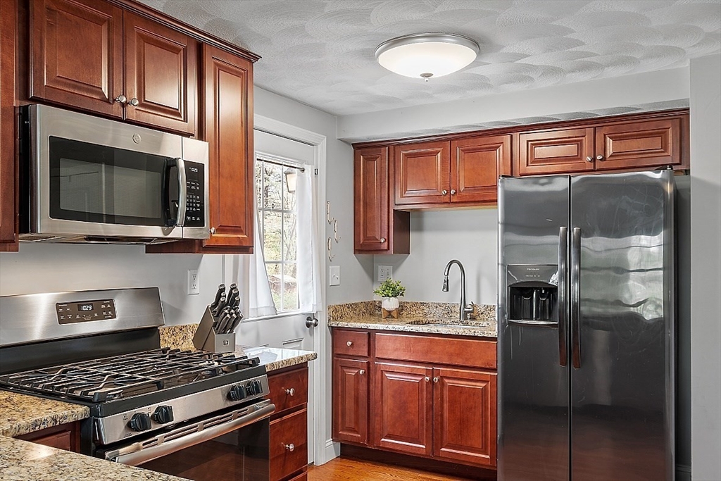 26 Pondover Road, Unit 26 Billerica, MA 01821 - Photo 4 of 23 a kitchen with stainless steel appliances granite countertop a refrigerator stove and sink