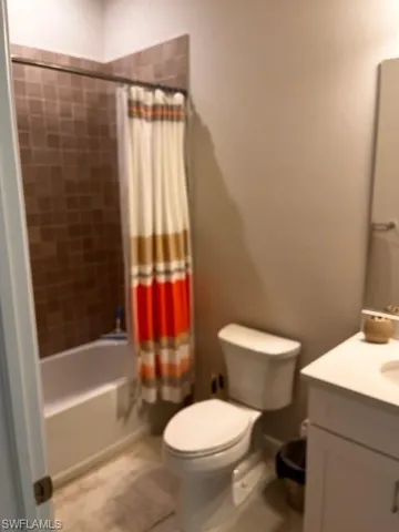 a white toilet sitting next to a bath tub