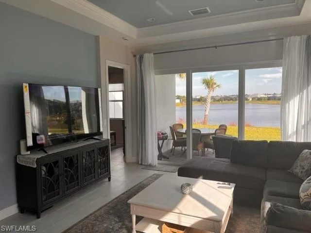 a living room with furniture a flat screen tv and a floor to ceiling window