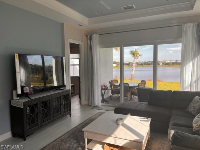9195 Cayman Drive Naples, FL 34114 - Photo 6 of 29 a living room with furniture a flat screen tv and a floor to ceiling window