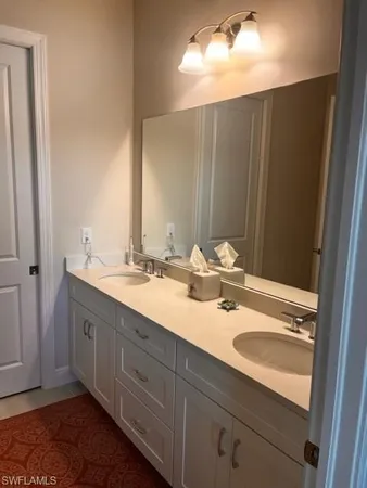 a bathroom with a double vanity sink and a mirror