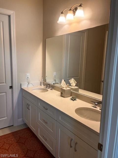 9195 Cayman Drive Naples, FL 34114 - Photo 9 of 29 a bathroom with a double vanity sink and a mirror