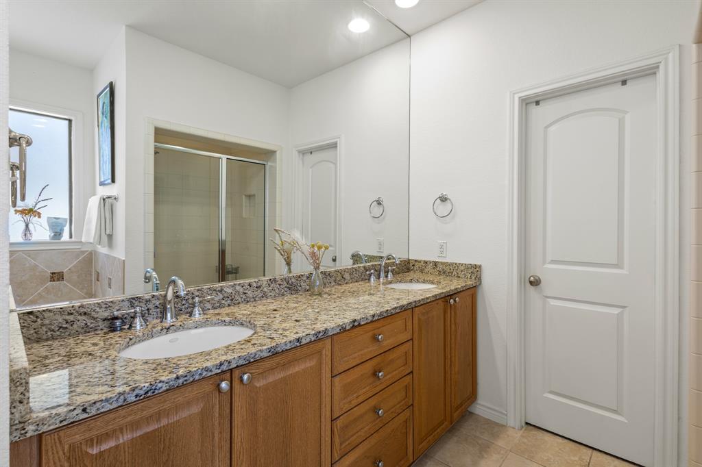13900 Noel Road, Unit 23 Dallas, TX 75240 - Photo 18 of 28 a bathroom with a granite countertop sink and a mirror