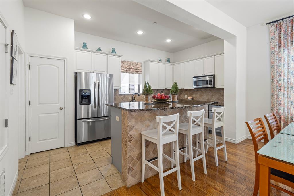 13900 Noel Road, Unit 23 Dallas, TX 75240 - Photo 9 of 28 a kitchen with stainless steel appliances a refrigerator stove microwave and white cabinets