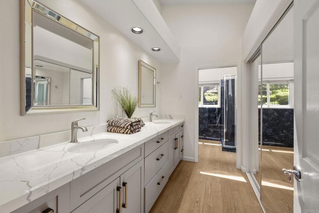 4939 Tilos Way Oceanside, CA 92056 - Photo 24 of 49 a spacious bathroom with a double vanity sink and mirror