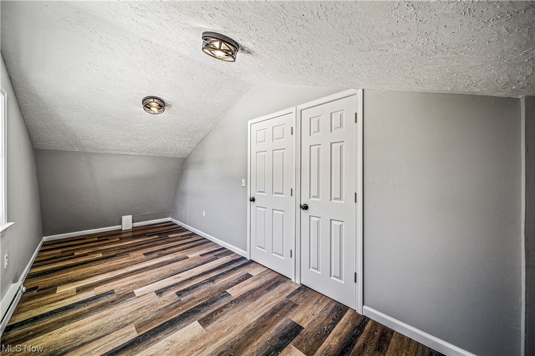 8790 Sumner Road Chardon, OH 44024 - Photo 25 of 46 Bonus room with a textured ceiling, lofted ceiling, and dark wood-type flooring