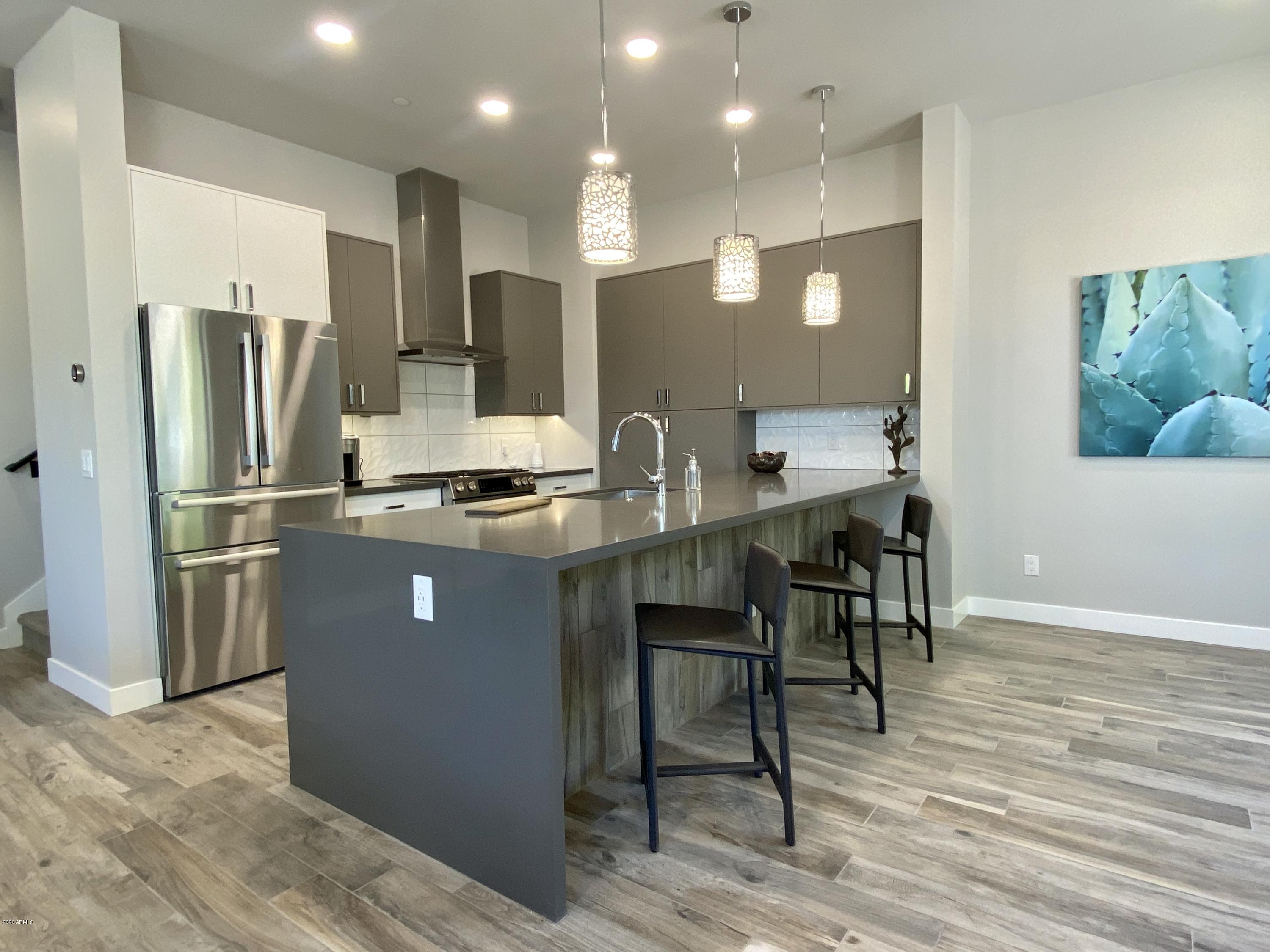 2645 East Osborn Road, Unit 6 Phoenix, AZ 85016 - Photo 4 of 43 a kitchen with stainless steel appliances kitchen island granite countertop a refrigerator and a stove top oven
