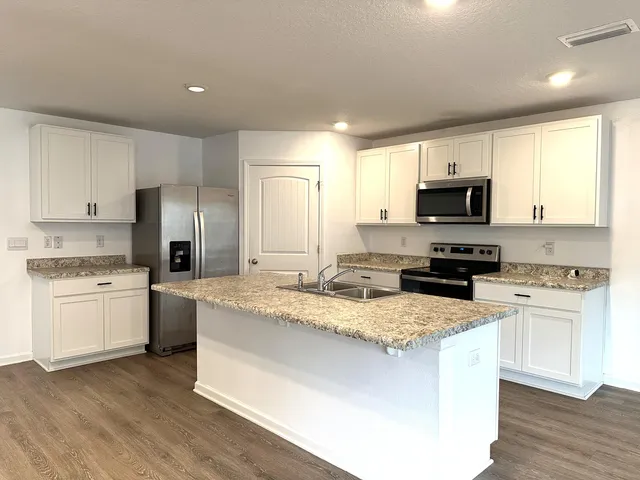 a kitchen with a sink a stove a refrigerator and a microwave