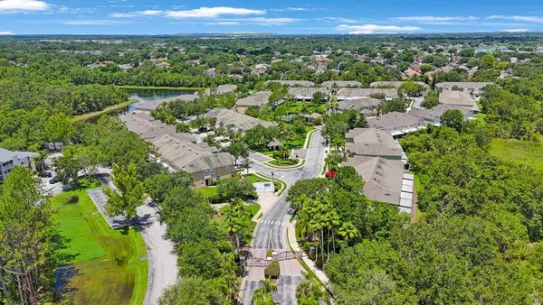 an aerial view of a house with a yard and lake view