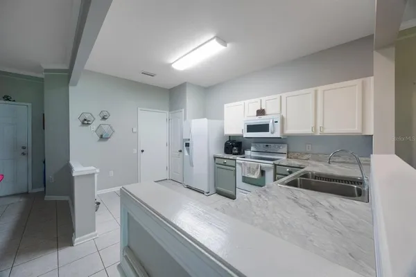 a kitchen with a sink a stove and a microwave