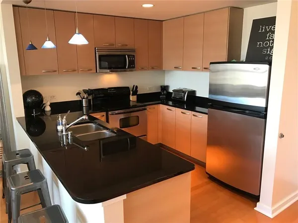 a kitchen with a sink a microwave a stove and cabinets