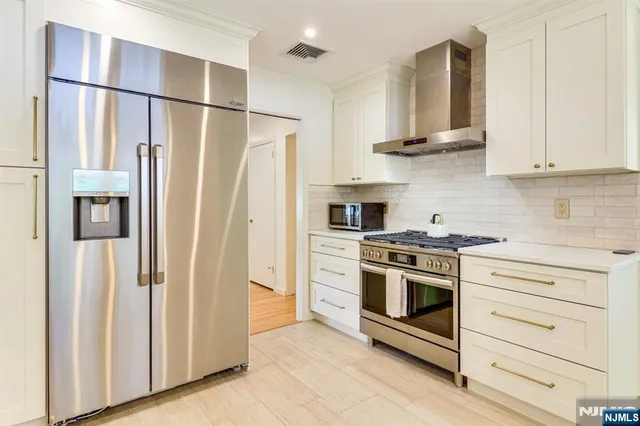 a kitchen with stainless steel appliances a refrigerator sink and cabinets