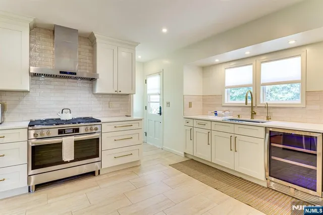 a kitchen with stainless steel appliances granite countertop a stove and white cabinets