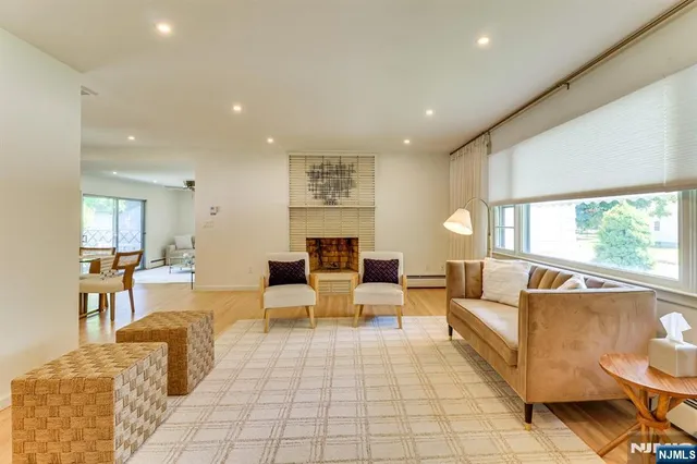 a living room with fireplace furniture and a large window