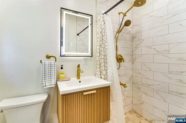 a bathroom with a sink a toilet and shower