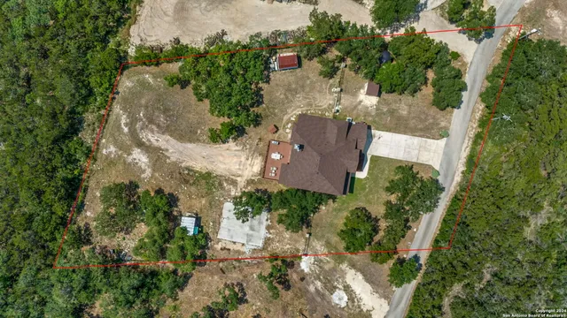 an aerial view of a house with a yard and a large tree