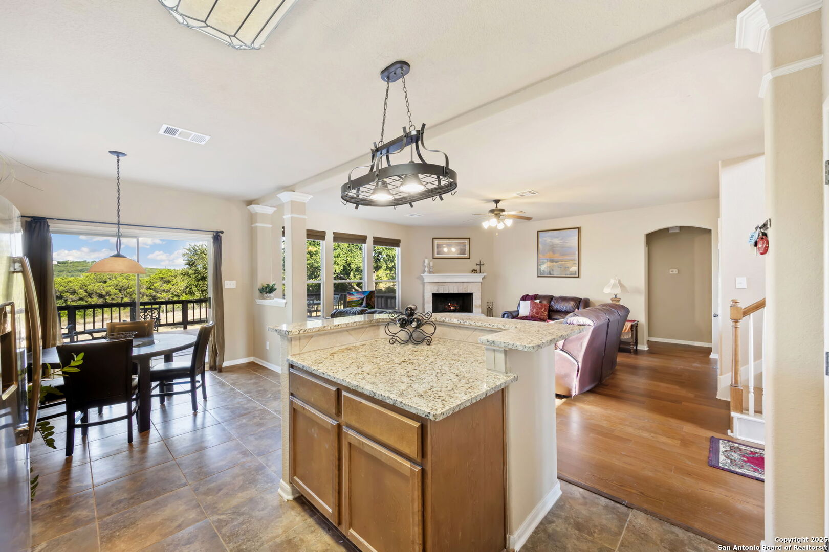17132 Bandera Road Helotes, TX 78023 - Photo 8 of 39 a view of a dining room and livingroom with furniture wooden floor a chandelier