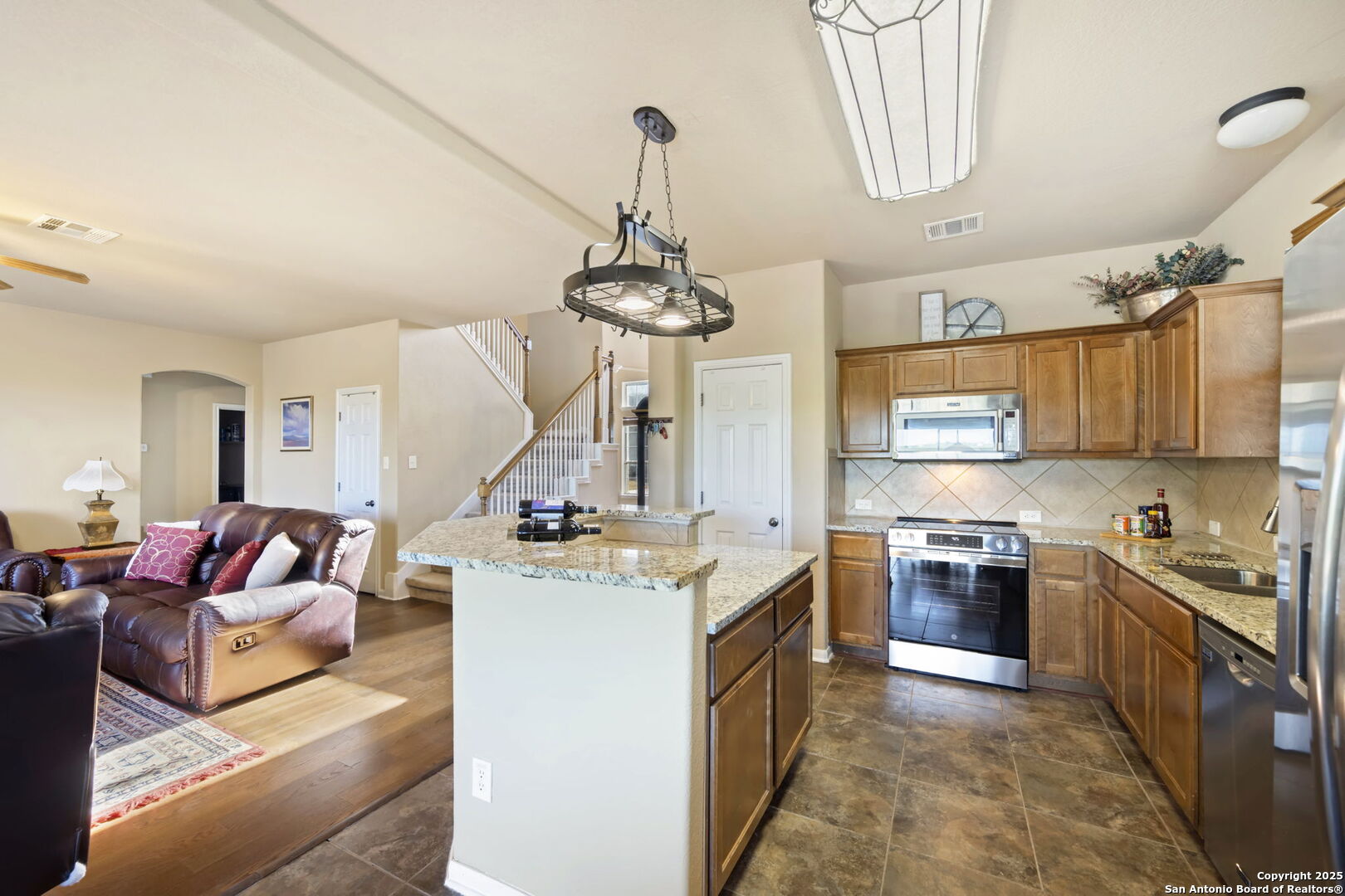 17132 Bandera Road Helotes, TX 78023 - Photo 9 of 39 a kitchen with kitchen island granite countertop a sink stove and refrigerator