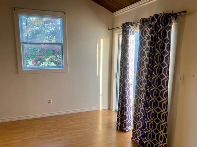 a view of an empty room with furniture and a window