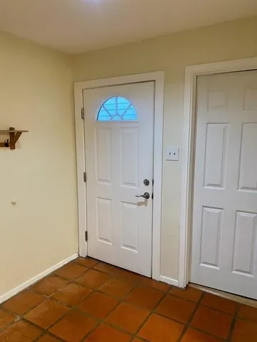 a view of empty room with floor to ceiling window and carpet