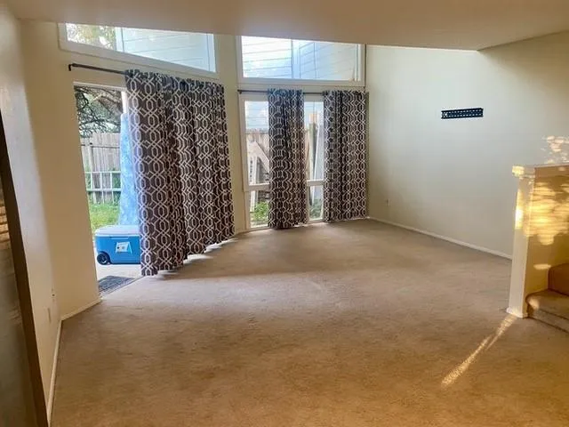 an empty room with a chandelier fan