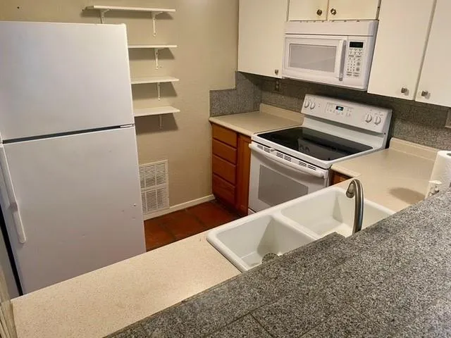 a view of a sink a counter space and a refrigerator
