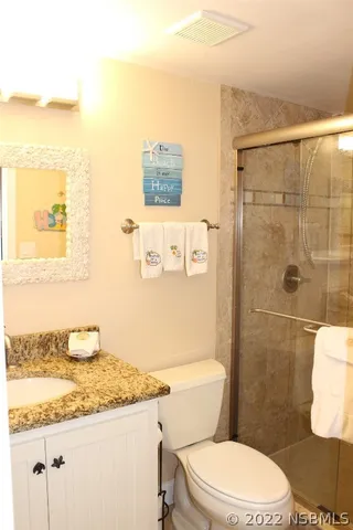 a bathroom with a granite countertop sink mirror vanity and toilet