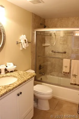a bathroom with a granite countertop sink a toilet and shower