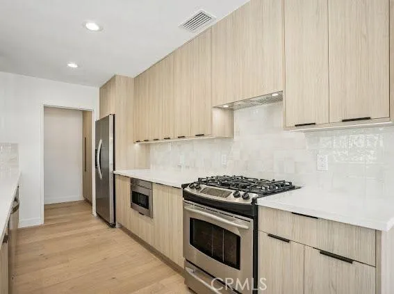 a kitchen with stainless steel appliances a stove a microwave and a refrigerator