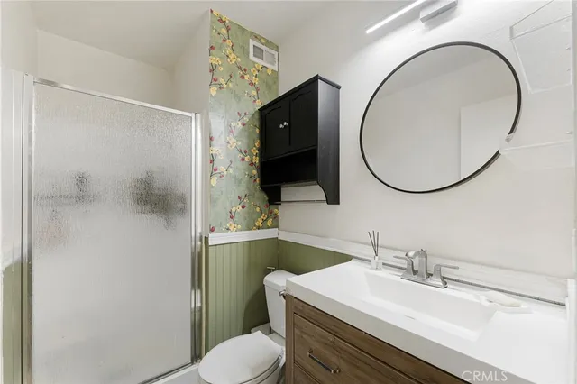 a bathroom with a sink vanity mirror and toilet