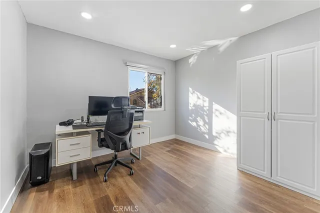 a view of workspace with wooden floor windows cabinet and chair