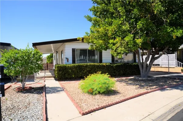 a front view of a house with a yard and a garden