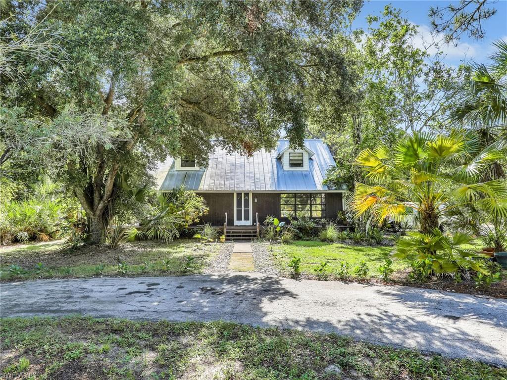 210 25th Street Southwest Naples, FL 34117 - Photo 1 of 33 View of front of home featuring a metal roof and a front lawn