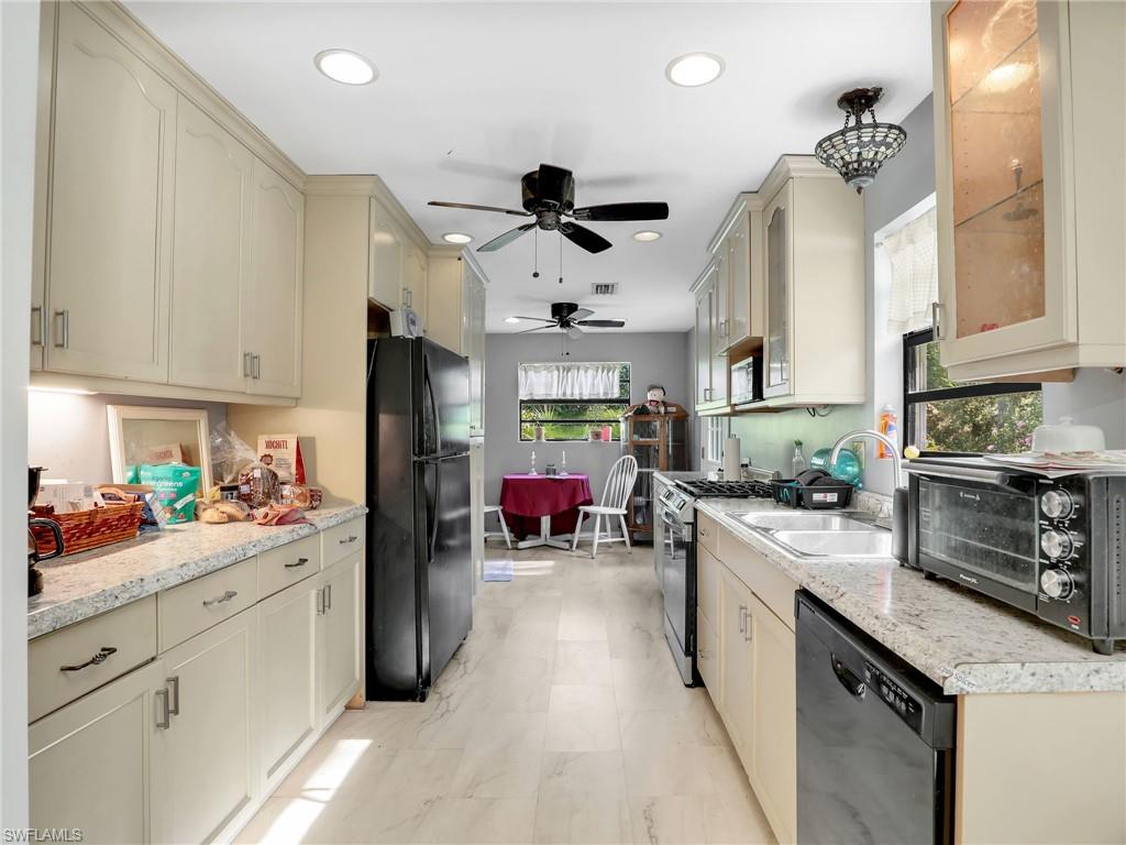 210 25th Street Southwest Naples, FL 34117 - Photo 11 of 33 Kitchen featuring cream cabinetry, black appliances, ceiling fan, healthy amount of natural light, and recessed lighting