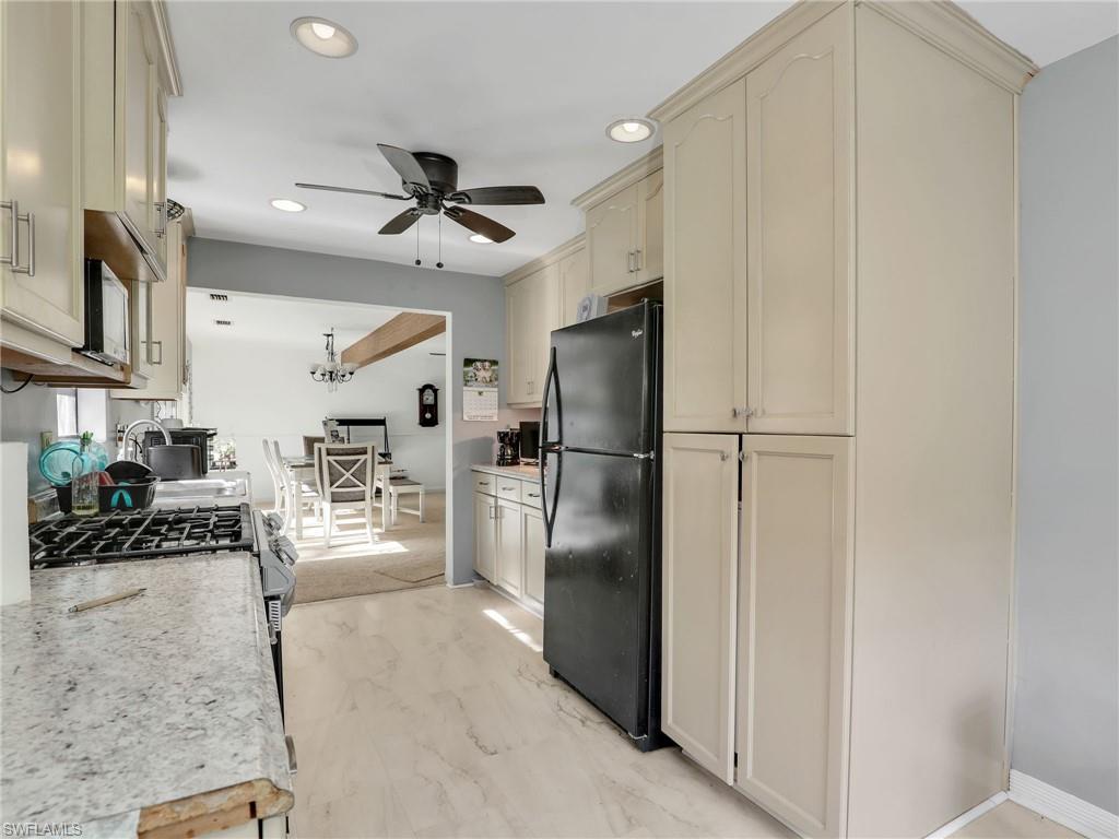 210 25th Street Southwest Naples, FL 34117 - Photo 14 of 33 Kitchen with freestanding refrigerator, cream cabinetry, recessed lighting, hanging light fixtures, and a chandelier