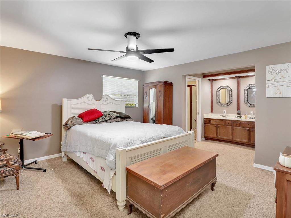 210 25th Street Southwest Naples, FL 34117 - Photo 16 of 33 Bedroom with light colored carpet, a ceiling fan, and connected bathroom